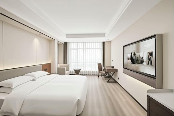 A modern hotel room with a large bed, a desk, a chair, and a television mounted on the wall. - Lanting Hotel (Danyang)