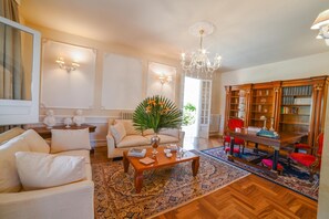 A well-lit living room with a sofa, armchair, coffee table, and a bookshelf. - Villa Nina - Luxury Villa With Pool in Salento (Zollino)