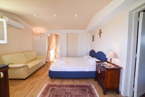 A bedroom with a bed, a sofa, a nightstand, and a door. - Villa Nina - Luxury Villa With Pool in Salento (Zollino)