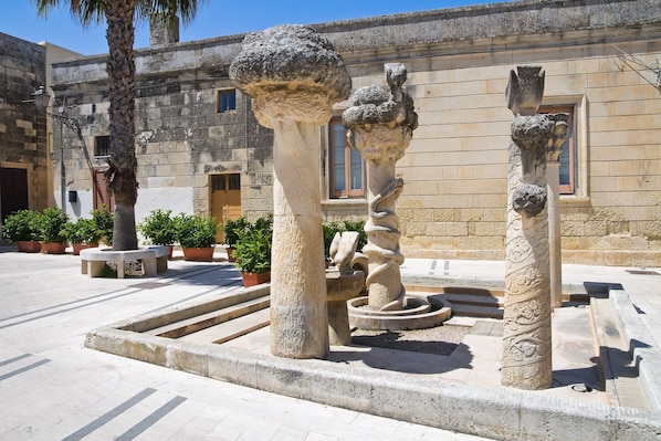 A courtyard with stone columns, a palm tree, and potted plants. - Villa Nina - Luxury Villa With Pool in Salento (Zollino)