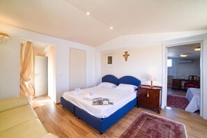 A bedroom with a bed, bedside table, lamp, and a door leading to another room. - Villa Nina - Luxury Villa With Pool in Salento (Zollino)