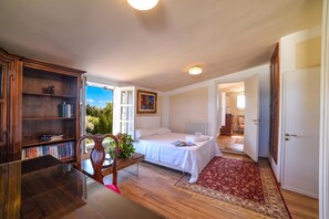 A bedroom with a bed, a desk, a chair, a bookshelf, and a view of the outdoors. - Villa Nina - Luxury Villa With Pool in Salento (Zollino)
