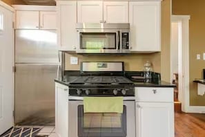 A kitchen with a stainless steel refrigerator, a microwave, a stove, and an oven. - Historic German Village Home/A+ Downtown Columbus Location (Columbus)