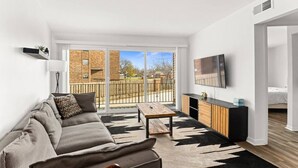 Ein modernes Wohnzimmer mit Sofa, Couchtisch und Fernseher.