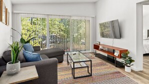 A modern living room with a sofa, coffee table, and TV. - Concord C6 · Slice of the Good Life: Concord C6 (Peoria)