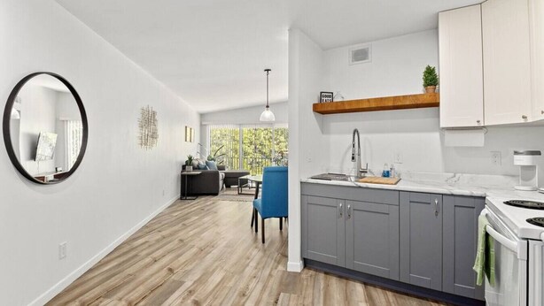 A modern kitchen with grey cabinets, a wooden countertop, and a built-in stove. - Concord C6 · Slice of the Good Life: Concord C6 (Peoria)