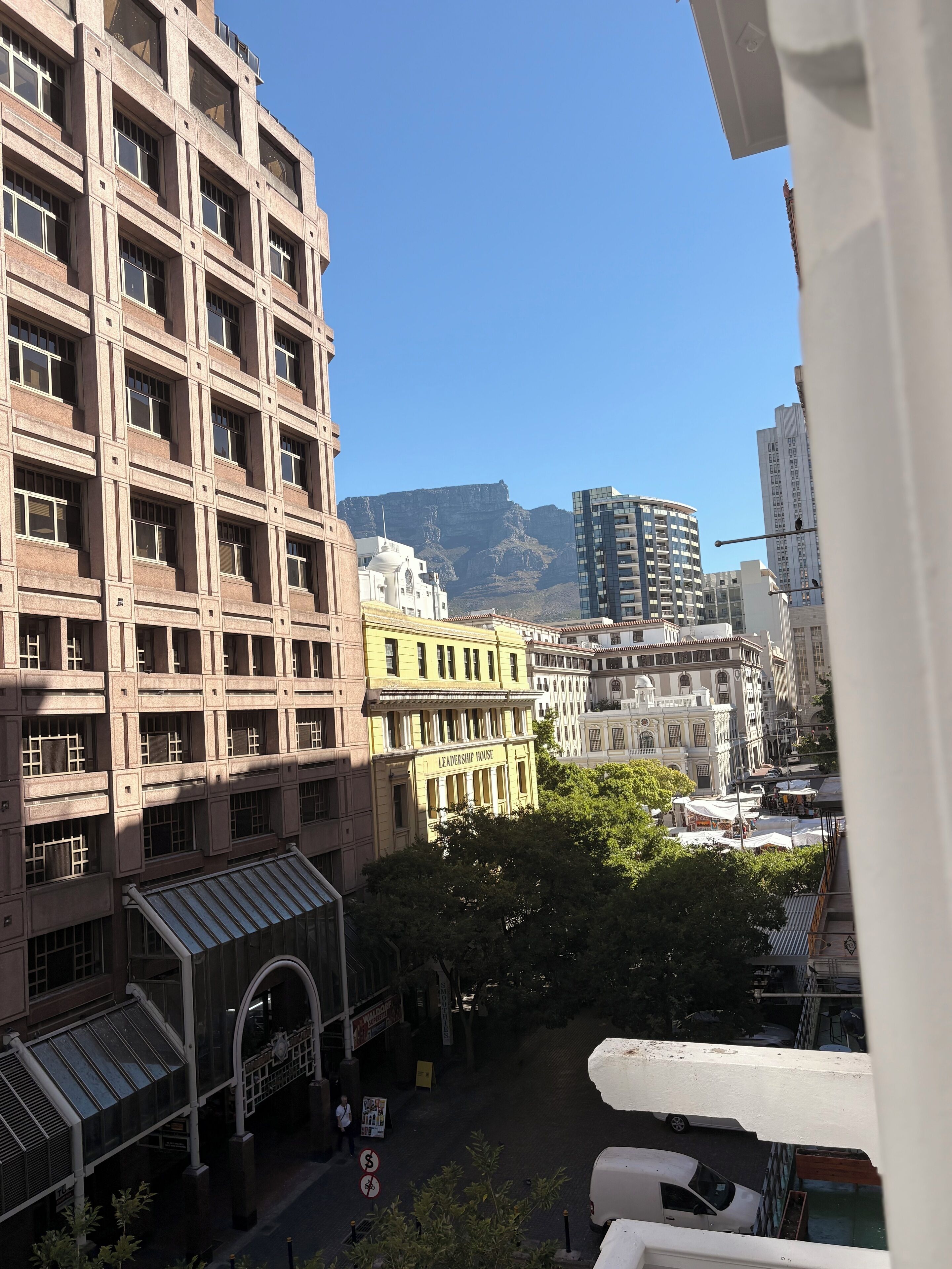 A cityscape with a prominent building labeled "Leadership House" and a mountain in the background.