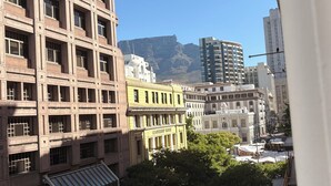 Un paisaje urbano con un edificio destacado identificado como 'Leadership House' y una montaña al fondo.