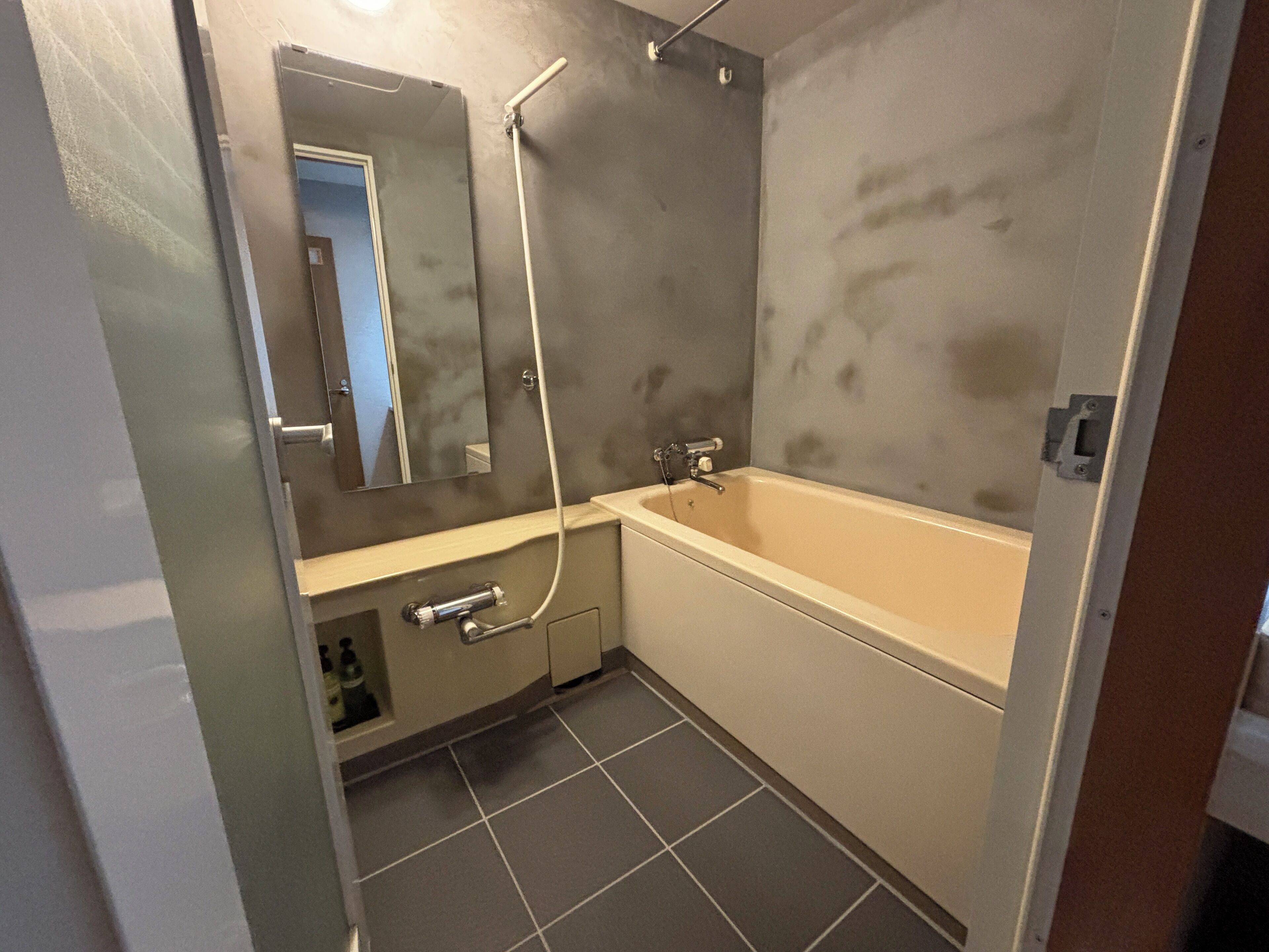 Un baño con bañera, ducha, espejo y lavamanos.