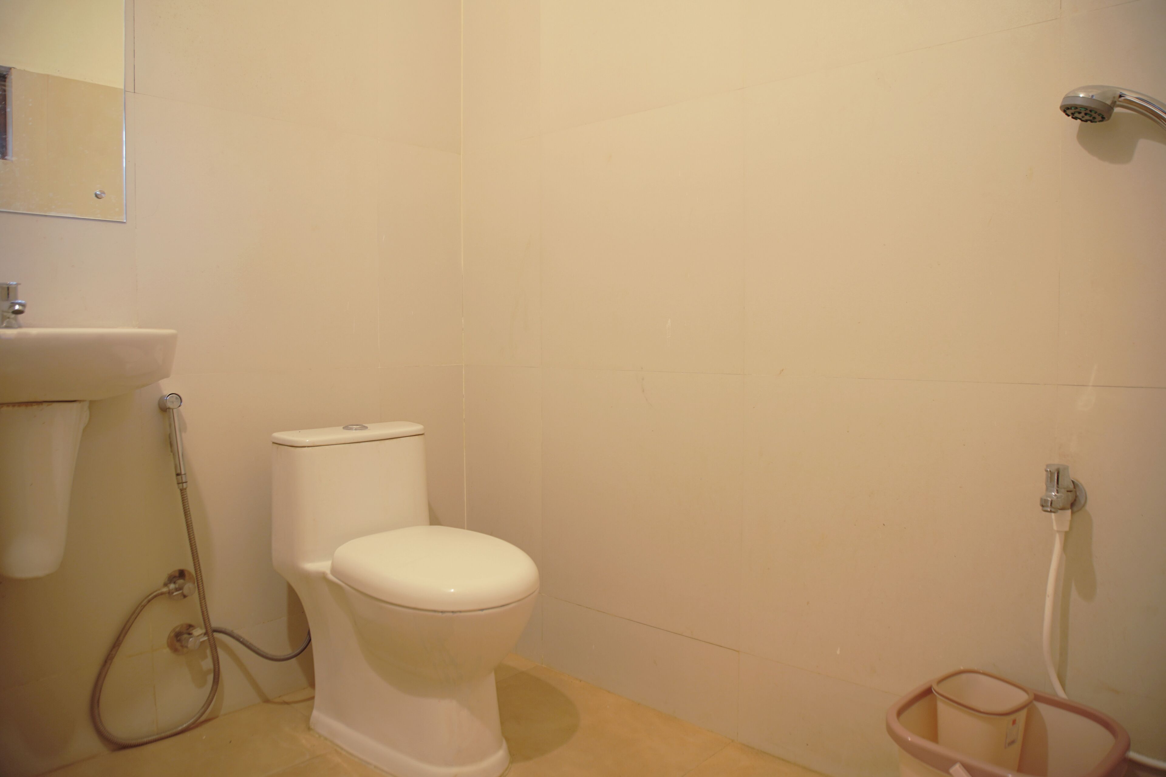 A bathroom with a toilet, sink, and shower.