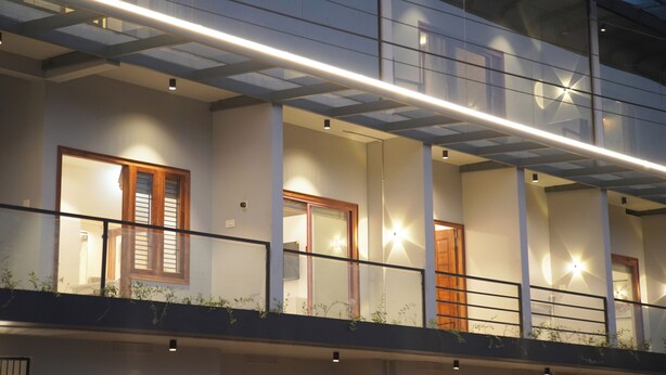 A modern building with multiple balconies, large windows, and a glass ceiling. - Gentur Enclave  (Mananthavady)
