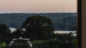 A room with a view of a lake and hills, a sofa with a floral cushion, and a stone vase. - The Haven Montville, is a place of peace, a refuge crowned, 
wrinkles fade & ... (Montville)
