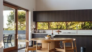 A modern kitchen with a large window, wooden dining table, and chairs. - The Haven Montville, is a place of peace, a refuge crowned, 
wrinkles fade & ... (Montville)