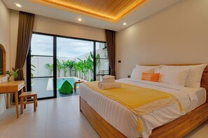 A modern bedroom with a large bed, a desk, and a view of a swimming pool and greenery. - Villa Dome - Sanur (Denpasar)