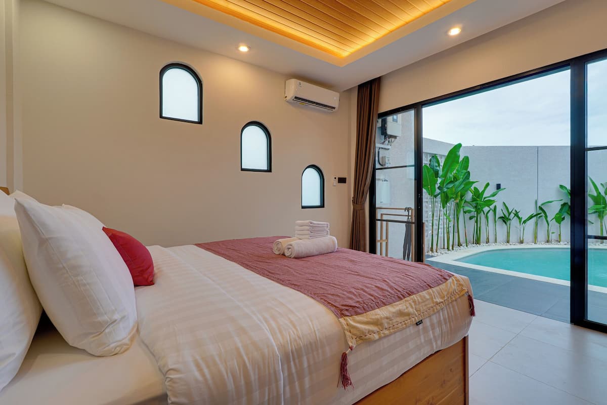 Une chambre avec un lit, une fenêtre et une vue sur une piscine.