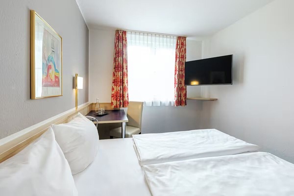 Settle into a bright, comfortable room with TV and workspace.