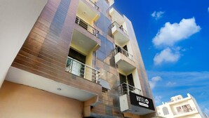 A multi-story hotel with a modern design, featuring balconies and a clear sky in the background. - Super Hotel O Sheetla Colony (Gurugram)