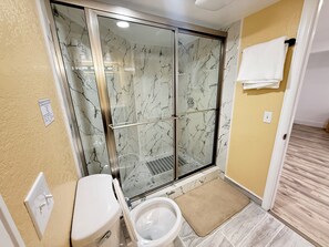A bathroom with a glass shower enclosure, a toilet, and a towel rack. - Spacious 3BR/2.5BA • 10 min to DIA• Private Entry (Denver)