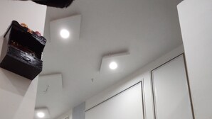 Een hal met witte wanden, marmeren vloer en inbouwverlichting.