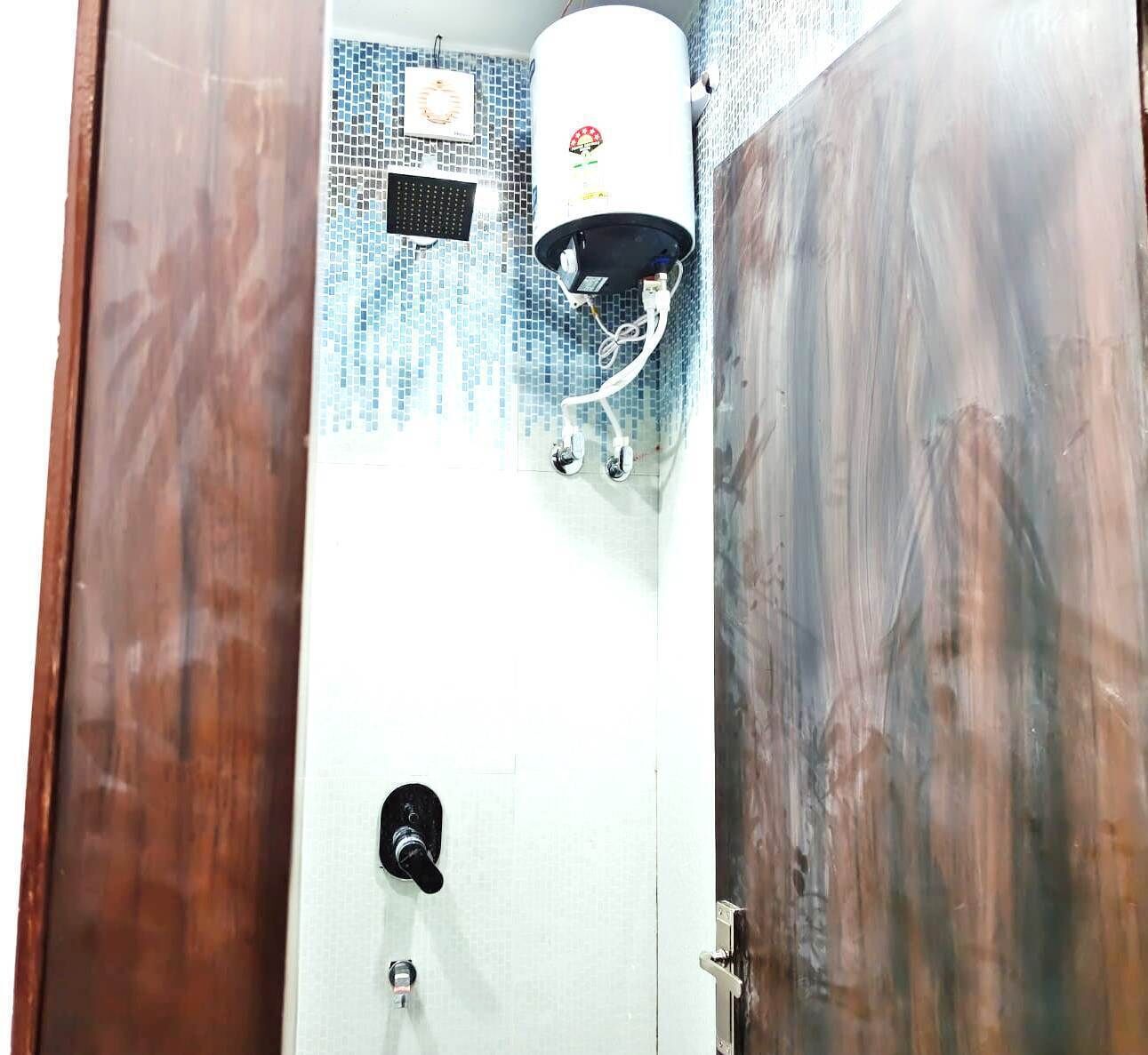 A bathroom with a shower, a toilet, and a water heater.