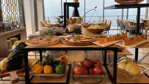 Ein reichhaltiges Buffet mit verschiedenen Speisen und Blick auf das Meer.