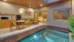 A modern interior with a pool, wooden furniture, and a kitchen area. - Villa Umahera - Canggu (Canggu)