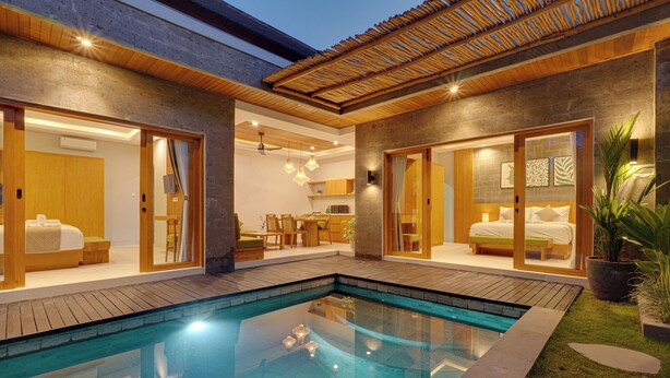 A modern house with a swimming pool, wooden flooring, and a dining area. - Villa Umahera - Canggu (Canggu)
