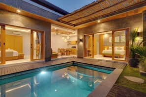 Una casa moderna con piscina, suelo de madera y un comedor.