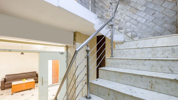 A staircase with a metal handrail leading to an upper floor. - Trevon Inn Karol Bagh, New Delhi (New Delhi)