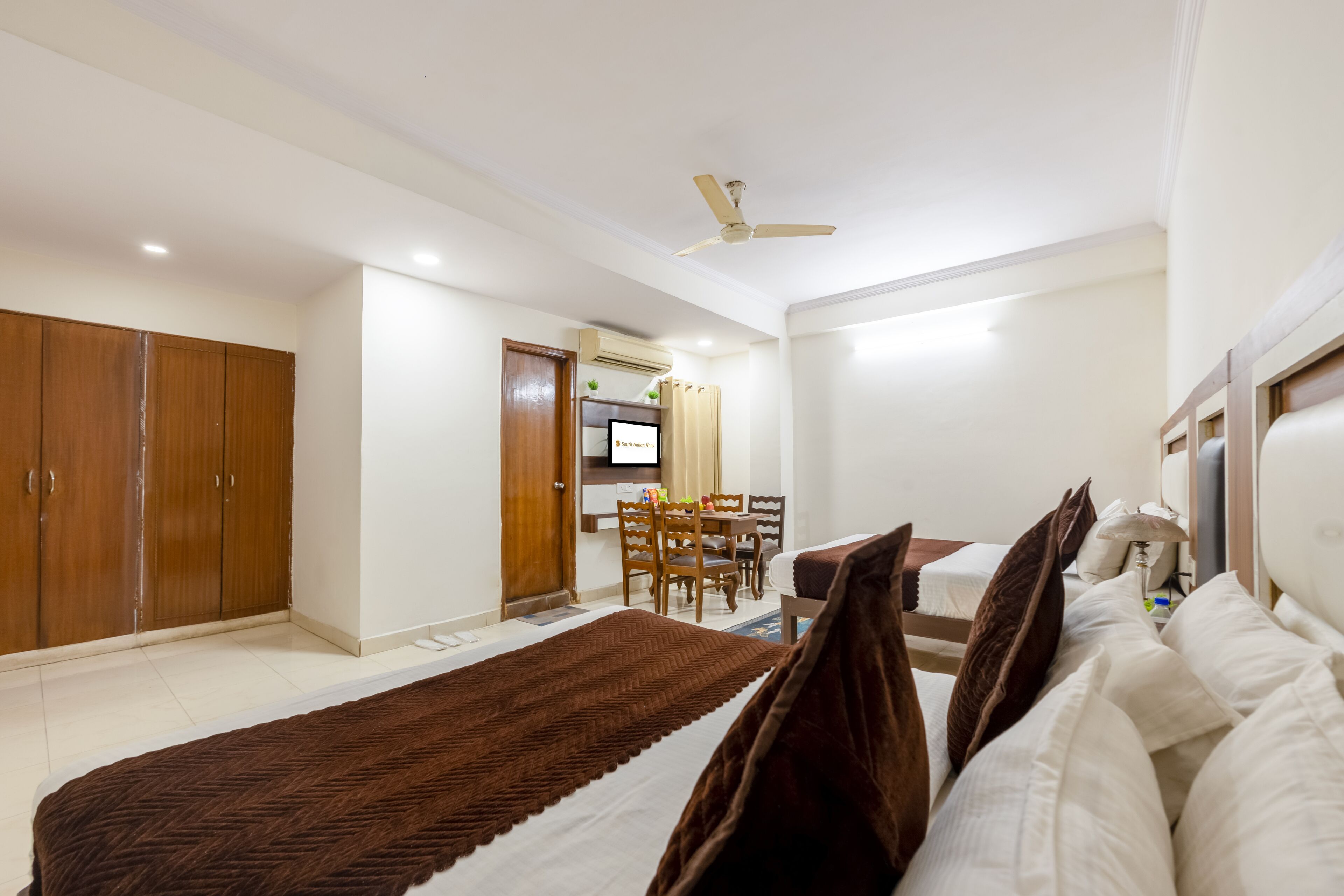 A hotel room with a bed, a desk, and a wardrobe.