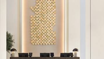 Un comptoir d’accueil au design moderne, agrémenté d’un motif hexagonal mural et caractérisé par une esthétique minimaliste.