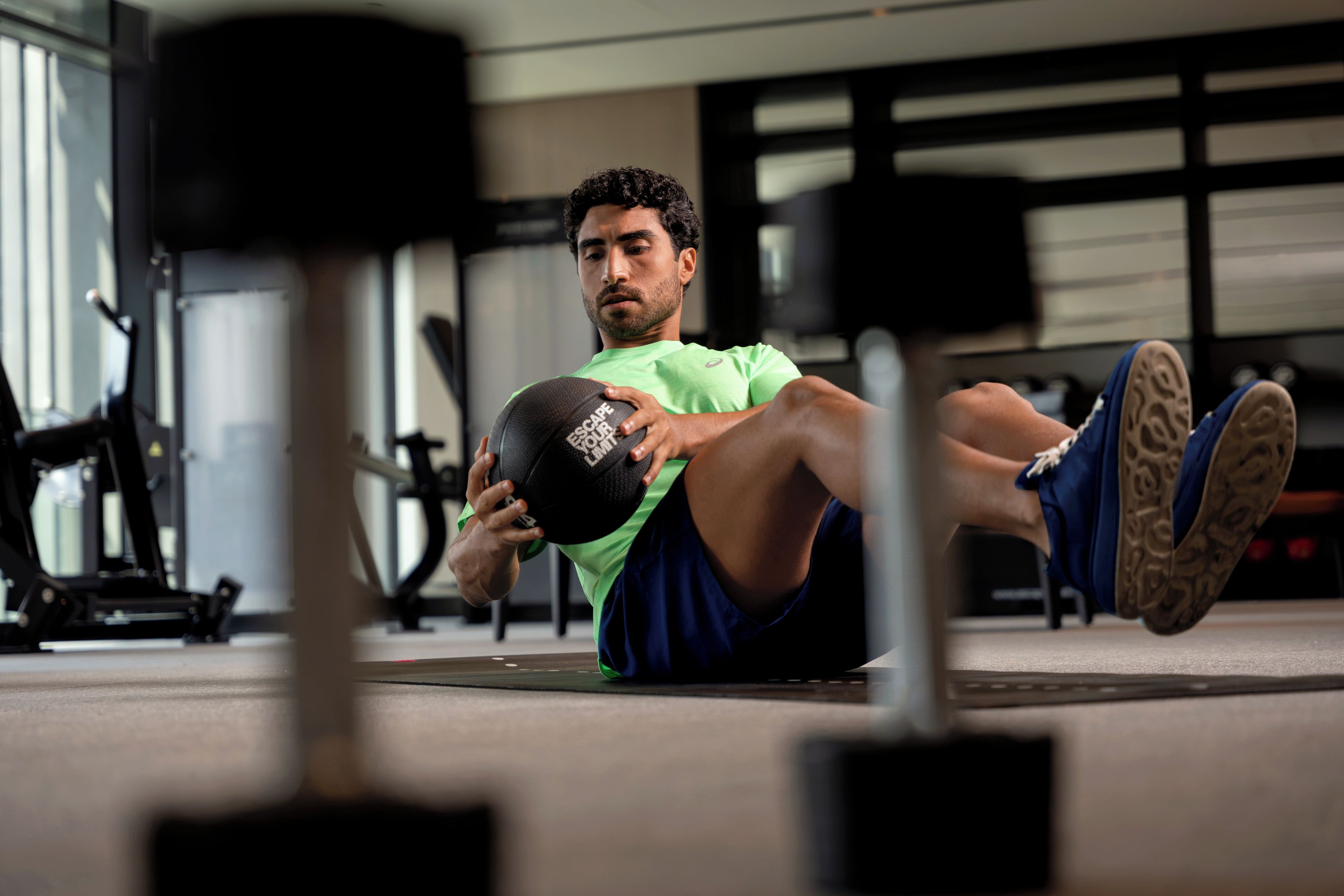 Uma pessoa fazendo exercício com uma bola medicinal em uma academia.