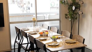 Uma mesa de jantar posta com pratos, tigelas e copos, rodeada por cadeiras.