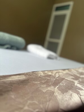 Un gros plan d’un lit avec une couvre-lit à motifs et un oreiller.
