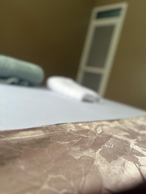 A close-up of a bed with a patterned bedspread and a pillow.