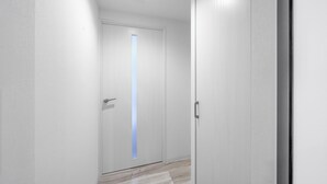 A narrow hallway with white walls and a wooden floor. - VOLPE 102 (Sapporo)