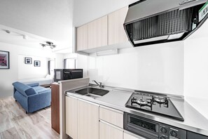 Appartement | Privékeuken | Een koelkast, een magnetron, een kookplaat, kookgerei, borden en bestek