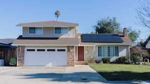 A two-story house with a garage, solar panels, and a well-maintained lawn.