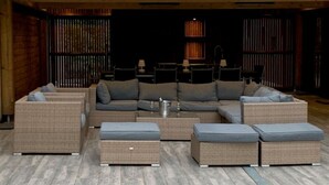 Una zona exterior acollidora amb mobiliari de vimet i un seient modular.