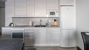 Eine kompakte Küche mit Einbauofen, Mikrowelle und Kühlschrank.