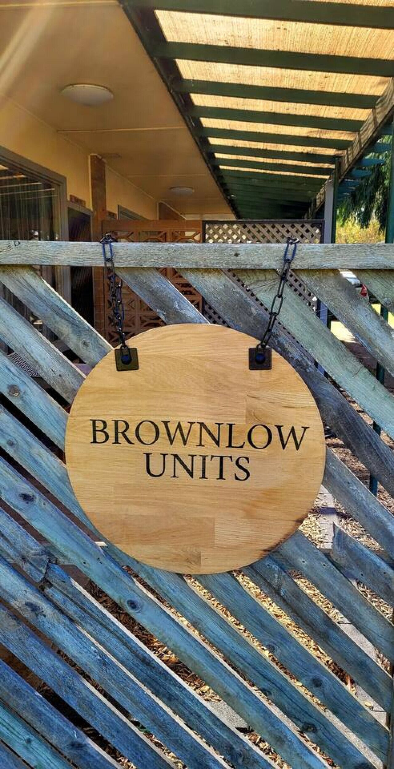 Puinen kyltti, jossa lukee ”BROWNLOW UNITS”, on ripustettu puiseen aitaan.