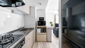 Cocina compacta con estufa a gas, microondas y refrigerador.