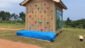 Una estructura de pared de escalada con revestimiento de madera y presas de colores.
