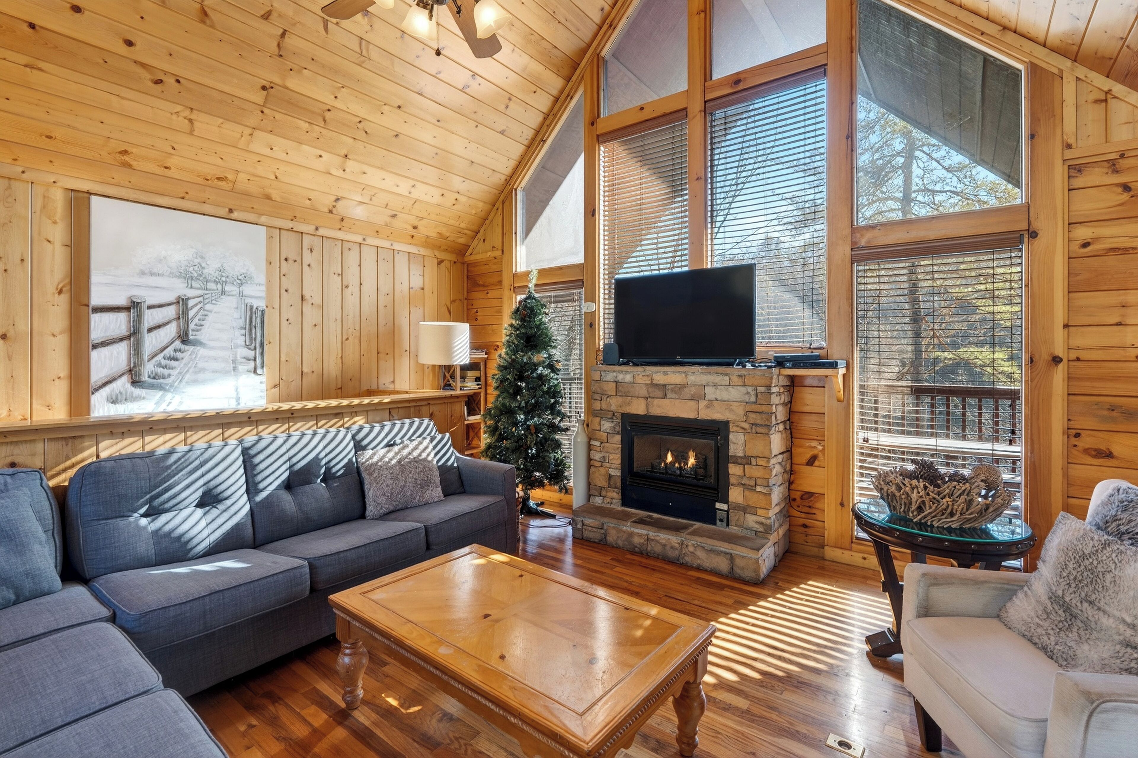 Living area featuring a large window, TV, sectional sofa, and a fireplace.