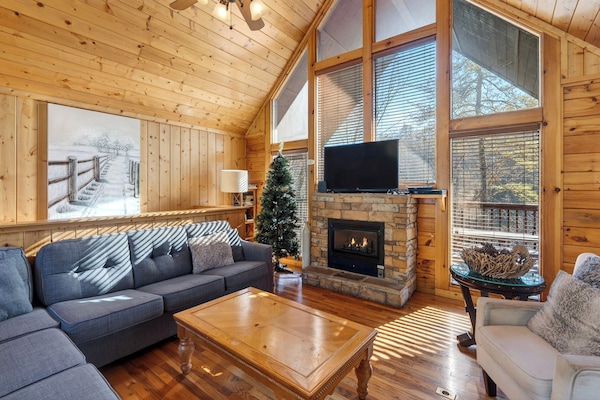 Living area featuring a large window, TV, sectional sofa, and a fireplace.