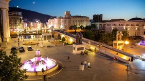 A public square with a central fountain, a statue, and surrounding buildings. - Stone Bridge Apartment (Skopje)