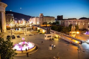 A public square with a central fountain, a statue, and surrounding buildings. - Stone Bridge Apartment (Skopje)