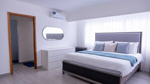 Ein modernes Schlafzimmer mit Bett, Nachttischen, einem Spiegel und einem Kleiderschrank.