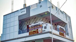 Een gebouw met twee opvallende borden die een verblijf bij Rayara Karune aanprijzen.