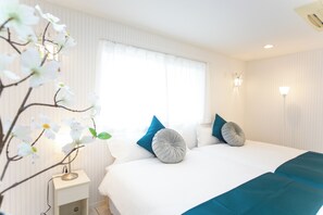 A hotel room with a bed, a nightstand, a lamp, and a window with curtains. - Awaji Smile Resort Kuruma (Awaji)